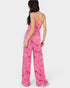 Woman wearing a pink patterned jumpsuit on a white background