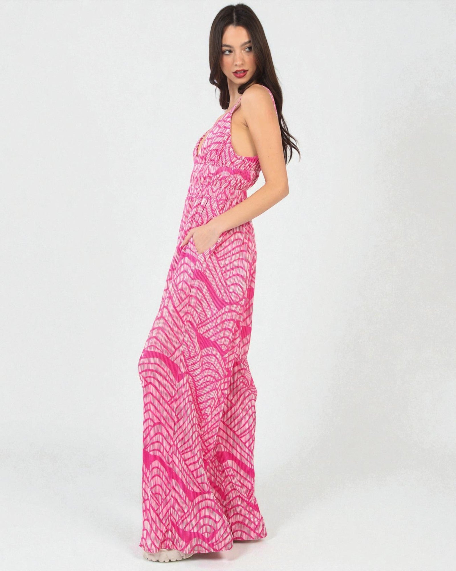 Woman wearing a pink patterned dress on a white background