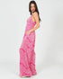 Woman wearing a pink patterned dress on a white background