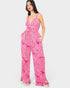 Woman wearing a pink and white patterned jumpsuit on a white background