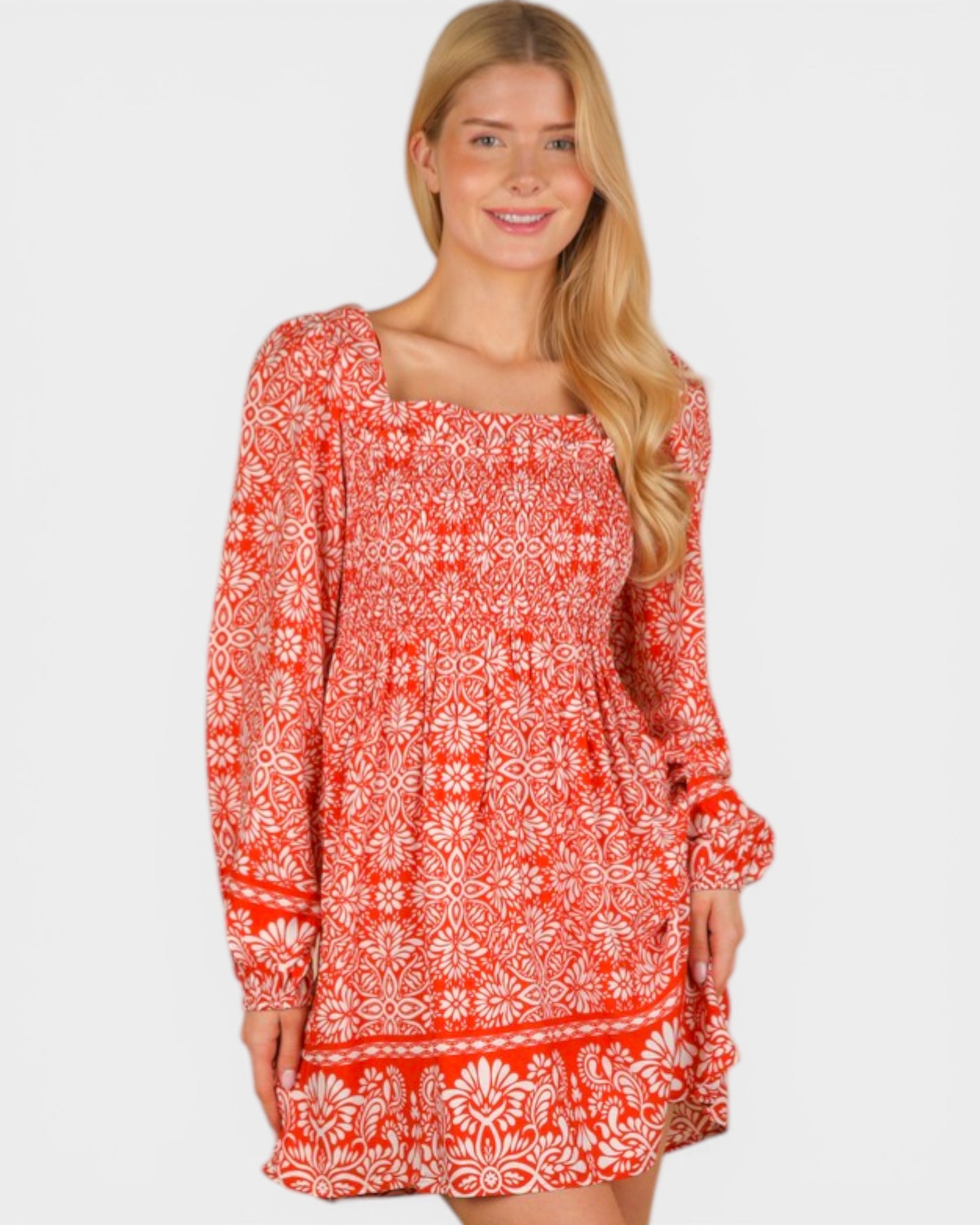 Woman wearing a red and white patterned dress on a plain background