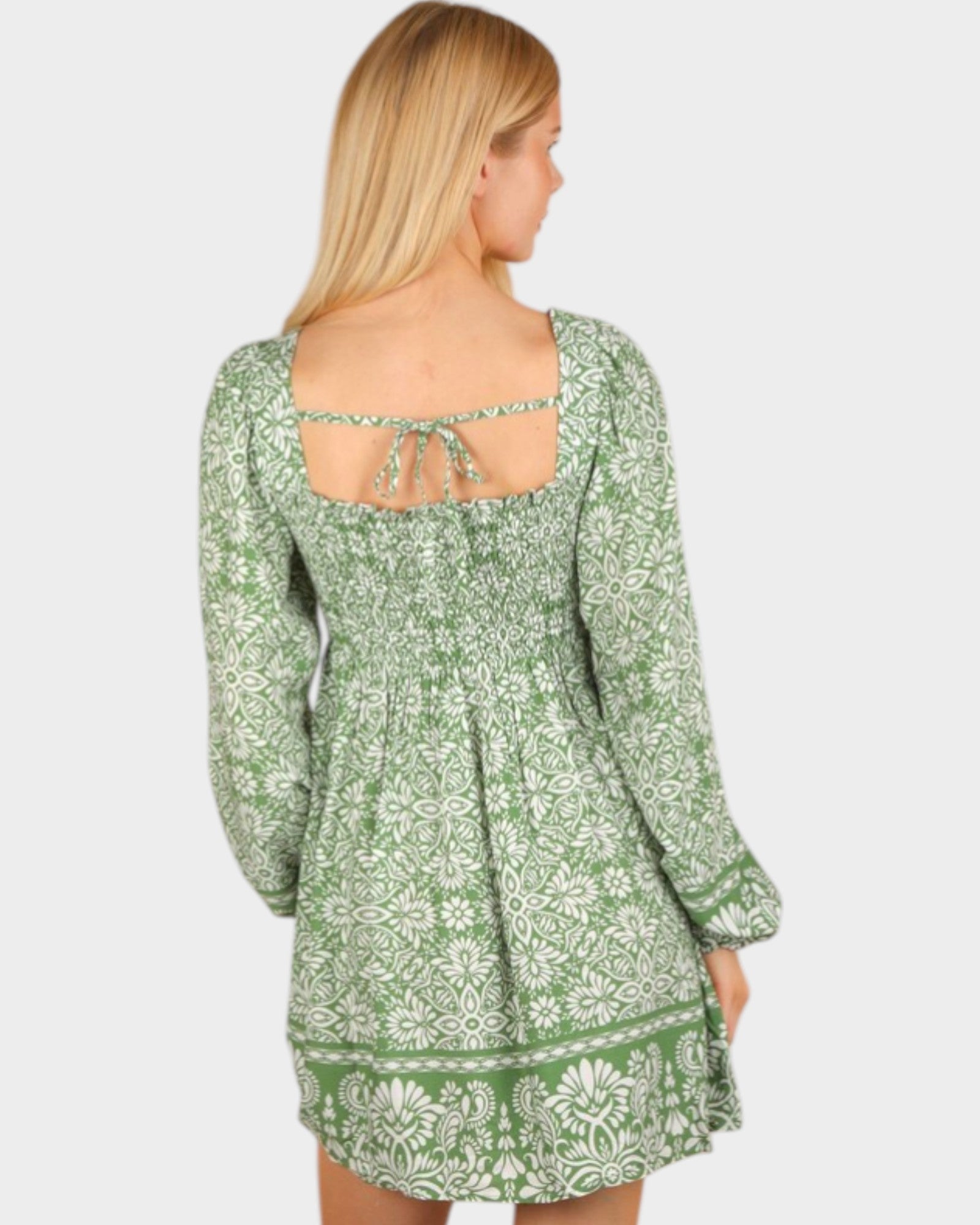 Green floral dress worn by a person on a white background
