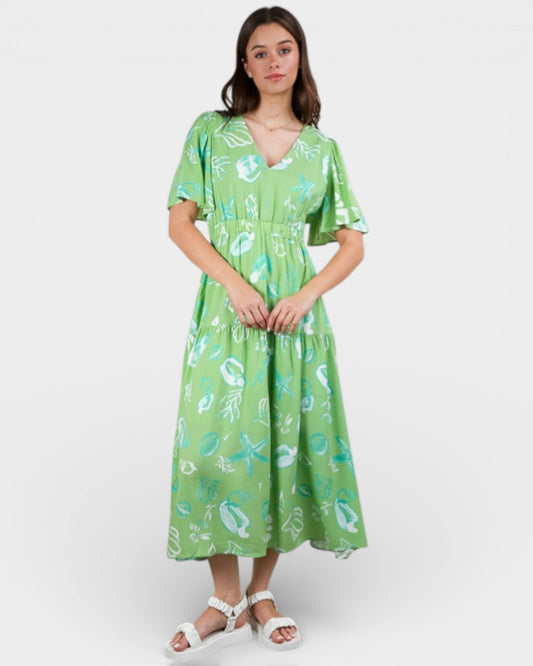 Woman wearing a green dress with a floral pattern on a white background