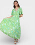 Woman wearing a green dress with a floral pattern on a white background