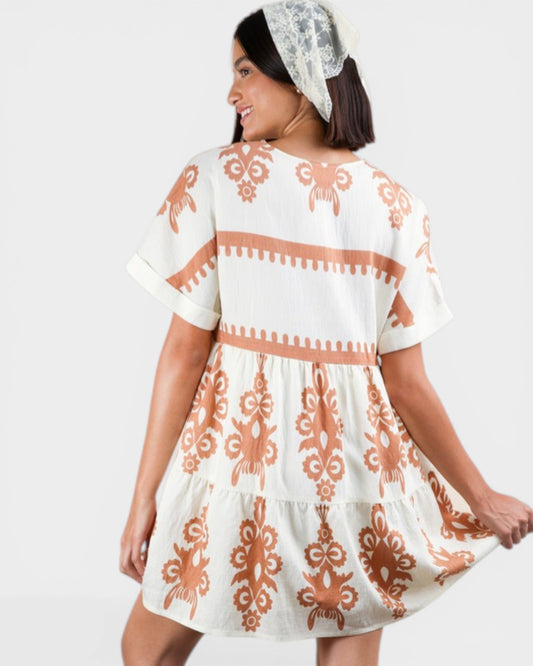 Woman wearing a white dress with orange patterns on a white background
