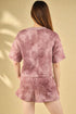 Person wearing a pink textured outfit on a beige background