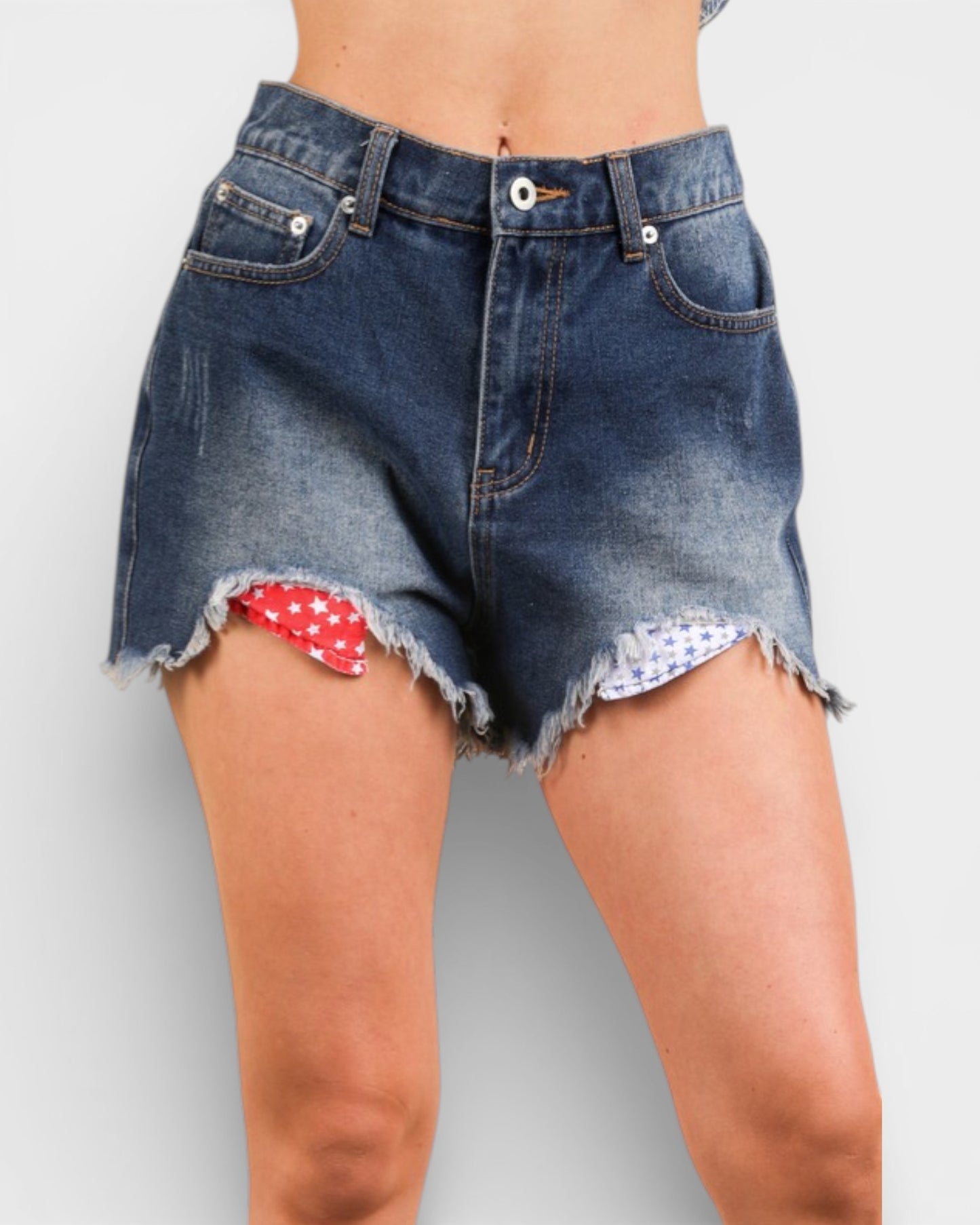 Denim shorts with a red and white pattern on a plain background