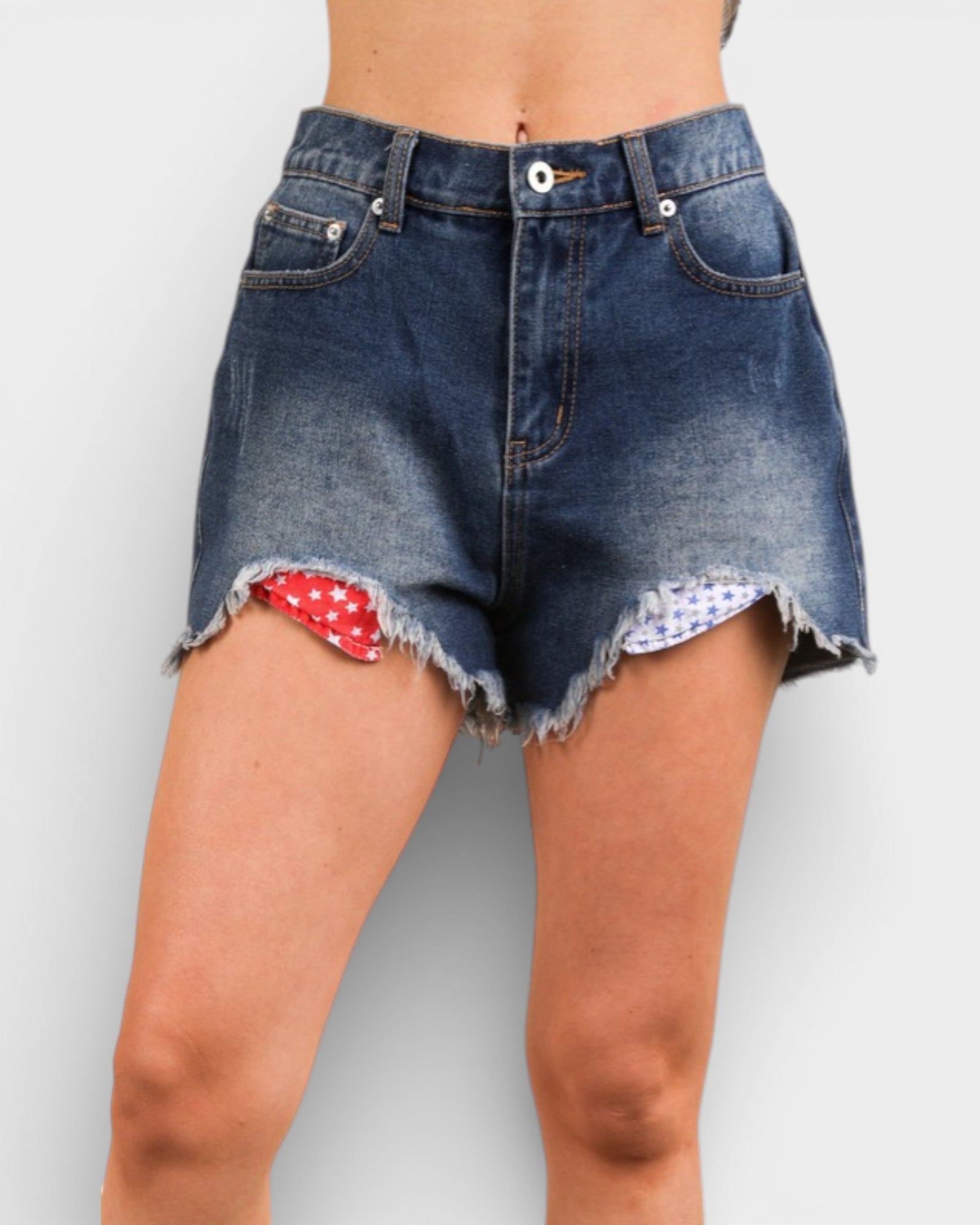 Denim shorts with a red and white patterned hem on a plain background