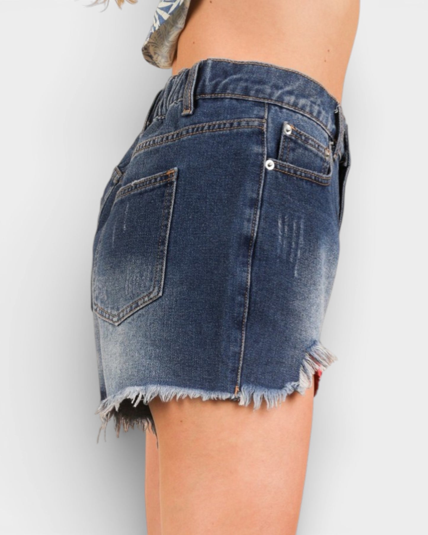 Denim skirt with frayed hem on a plain background