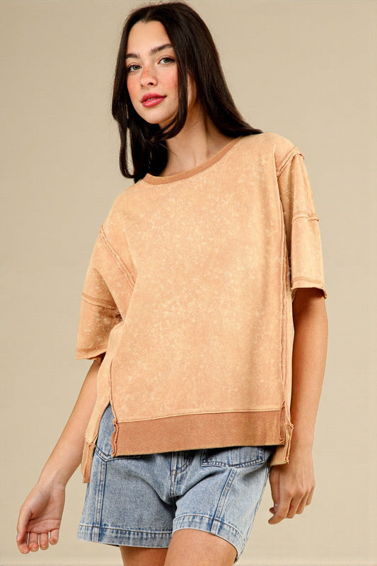 Woman wearing a beige sweater and denim shorts on a beige background