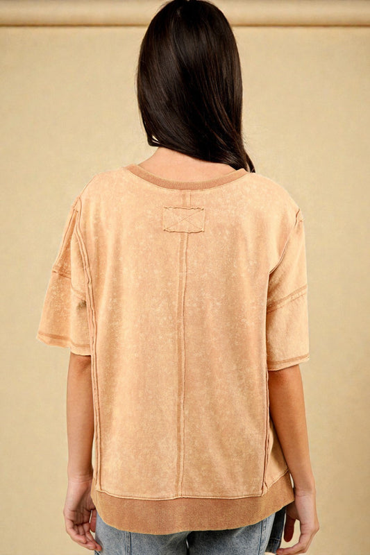 Person wearing a beige top with a plain background