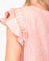 Close-up of a model wearing a light pink textured top with ruffled cap sleeves and vertical pleats.