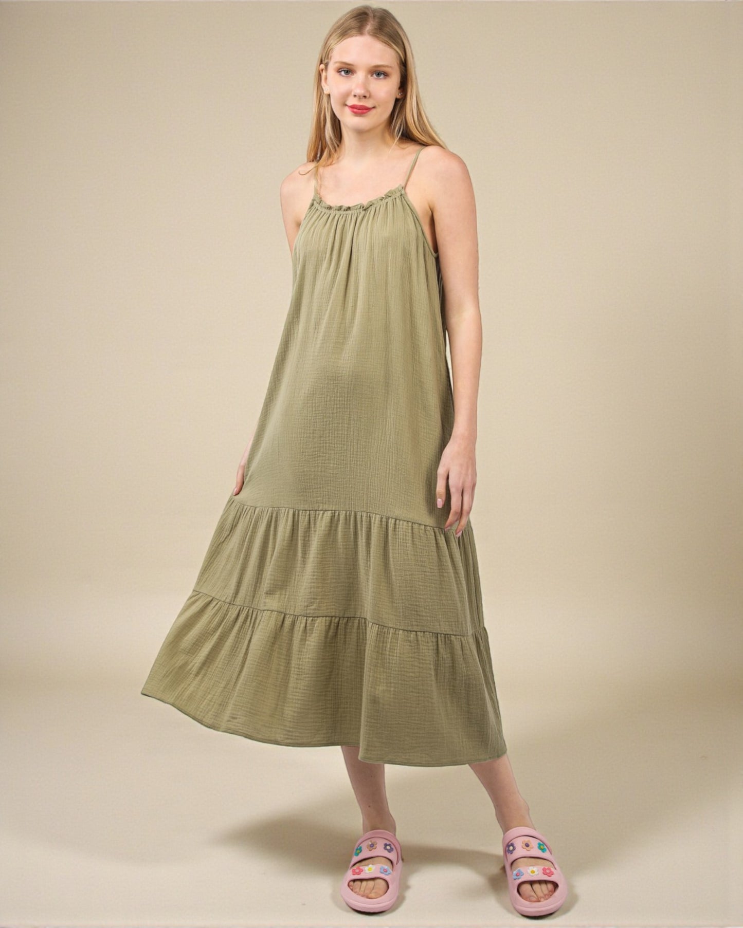 Woman wearing a green dress against a beige background