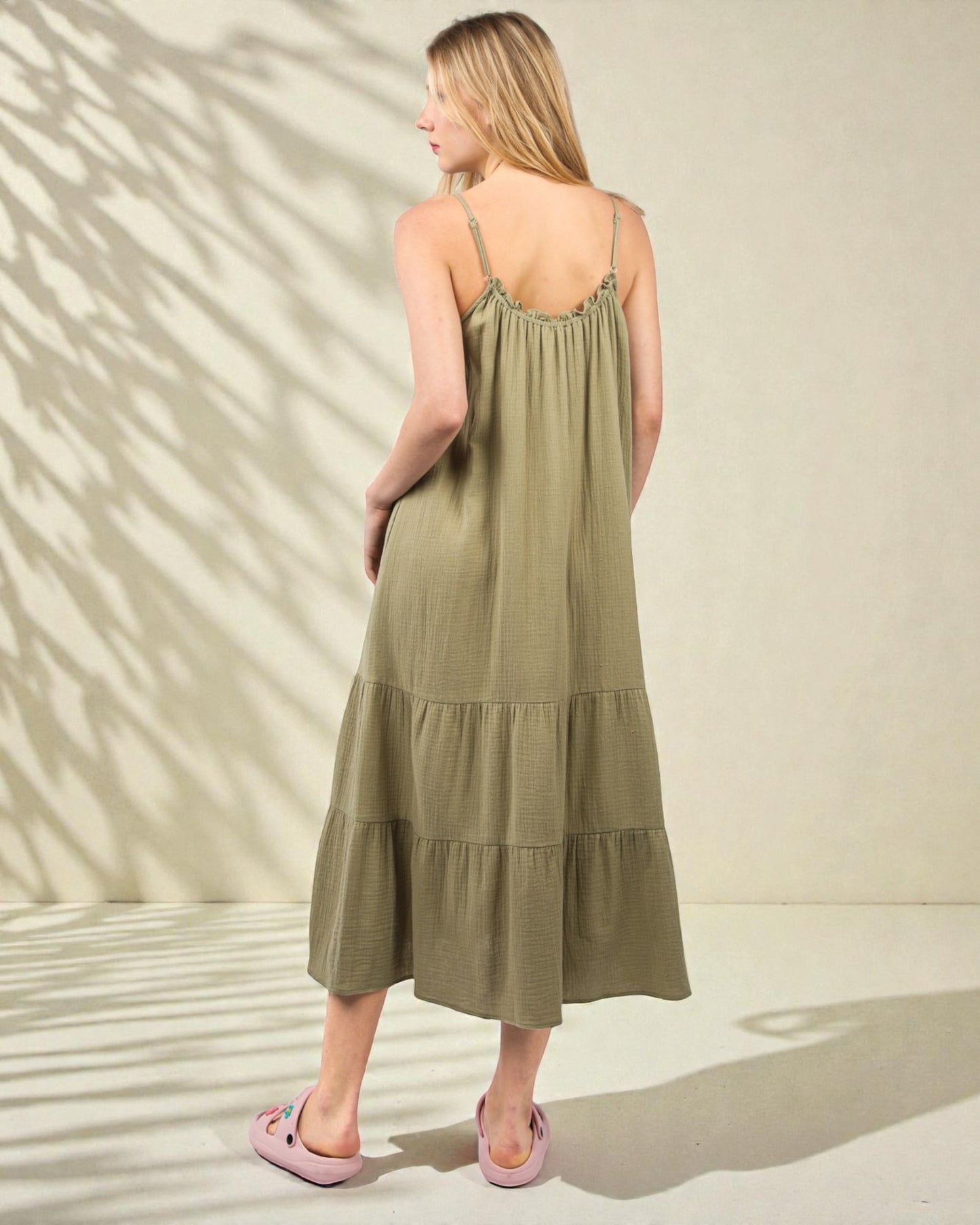 Woman wearing a green dress with a beige background