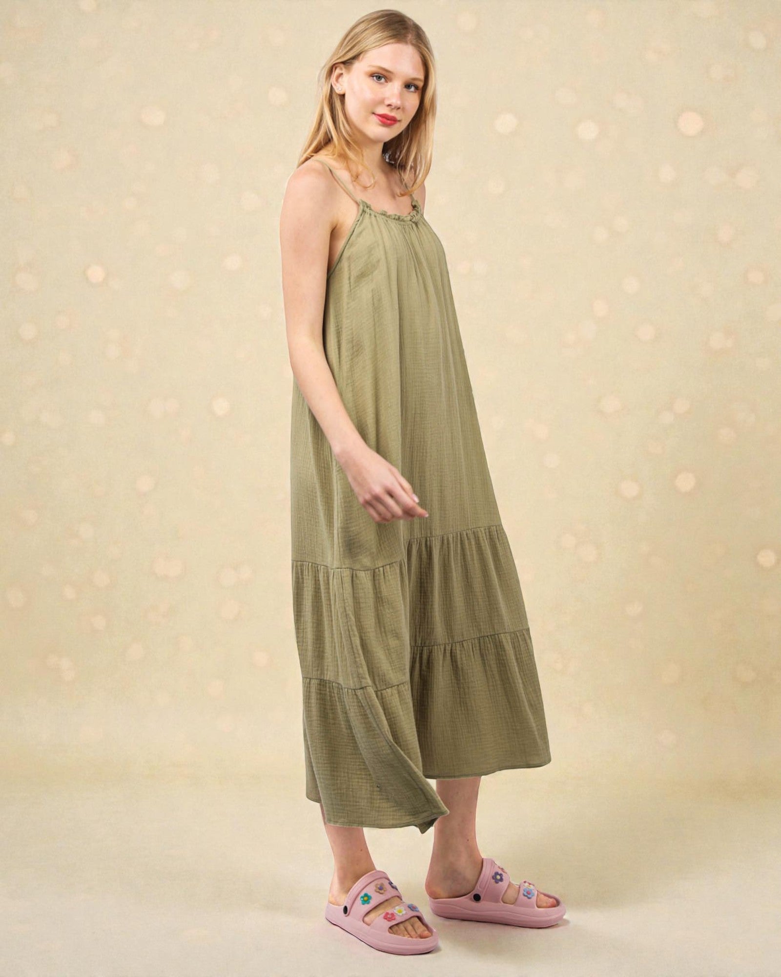 Woman wearing a green dress with a beige background