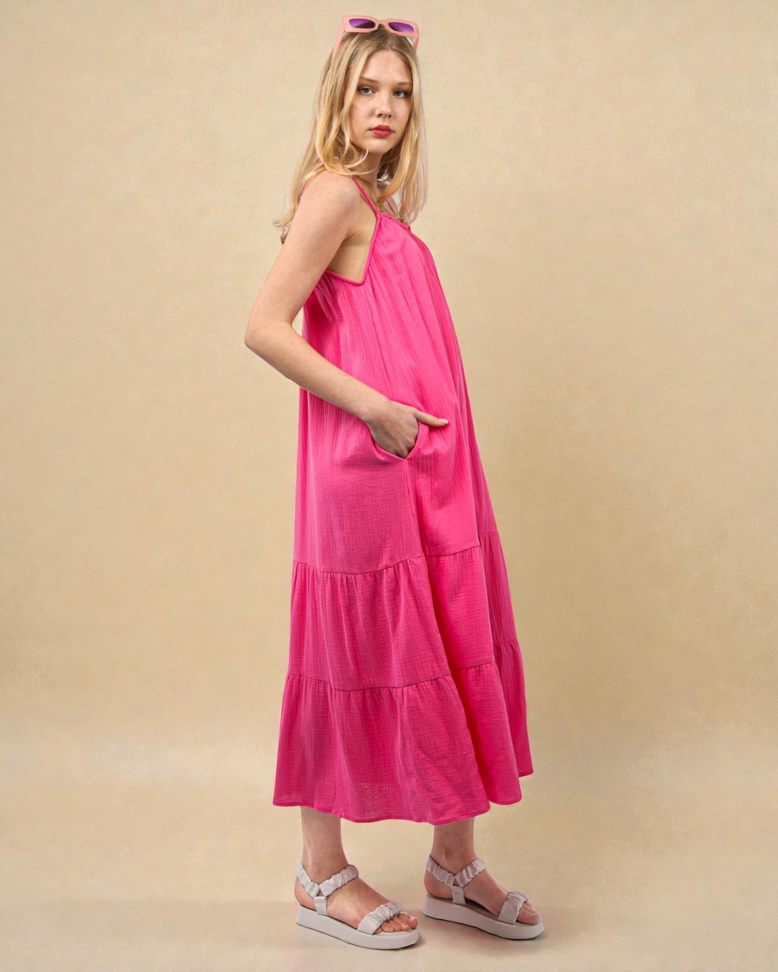Woman wearing a pink dress against a beige background