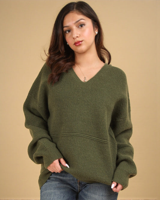 Woman wearing an olive green sweater against a beige background