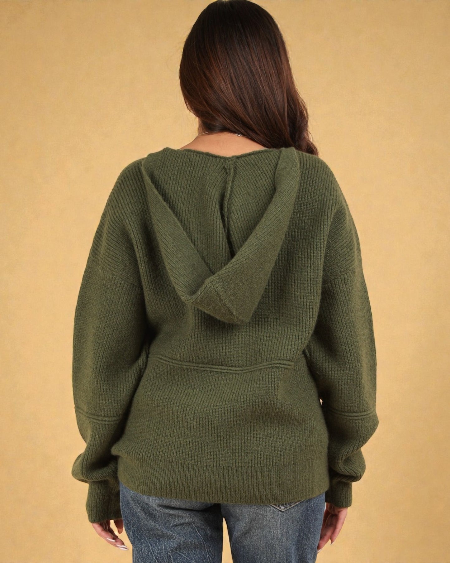 Person wearing a green hoodie with a beige background