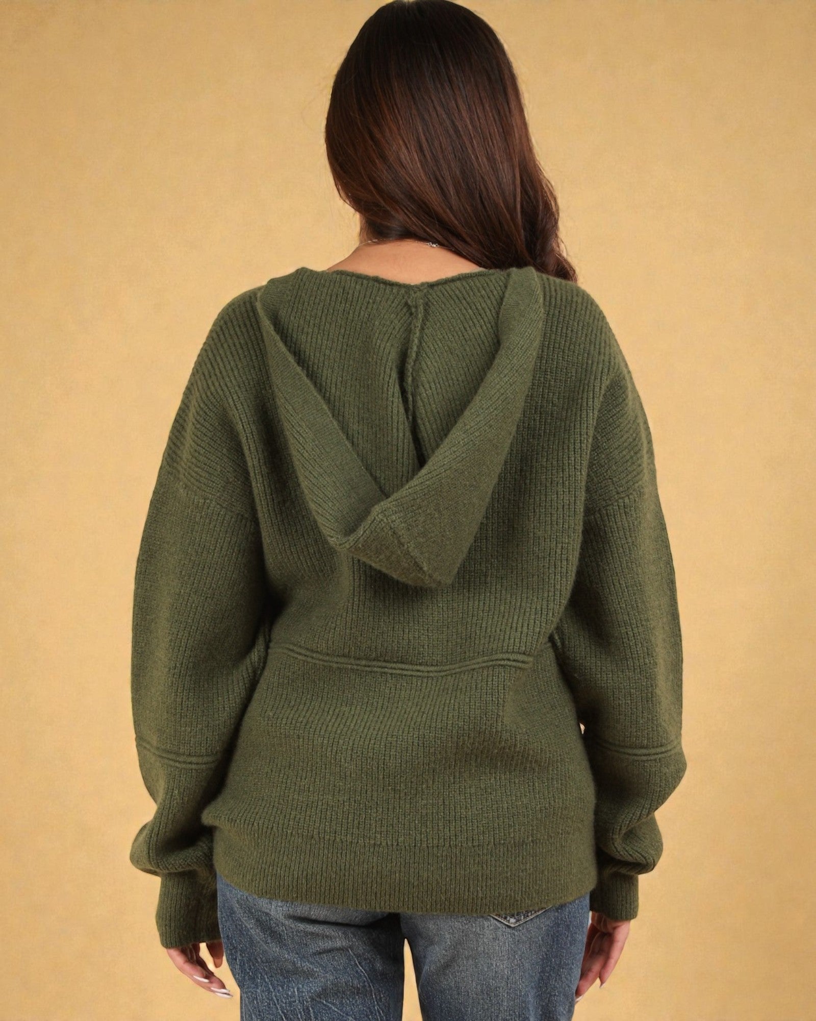 Person wearing a green hoodie with a beige background
