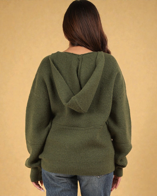Person wearing a green hoodie with a beige background