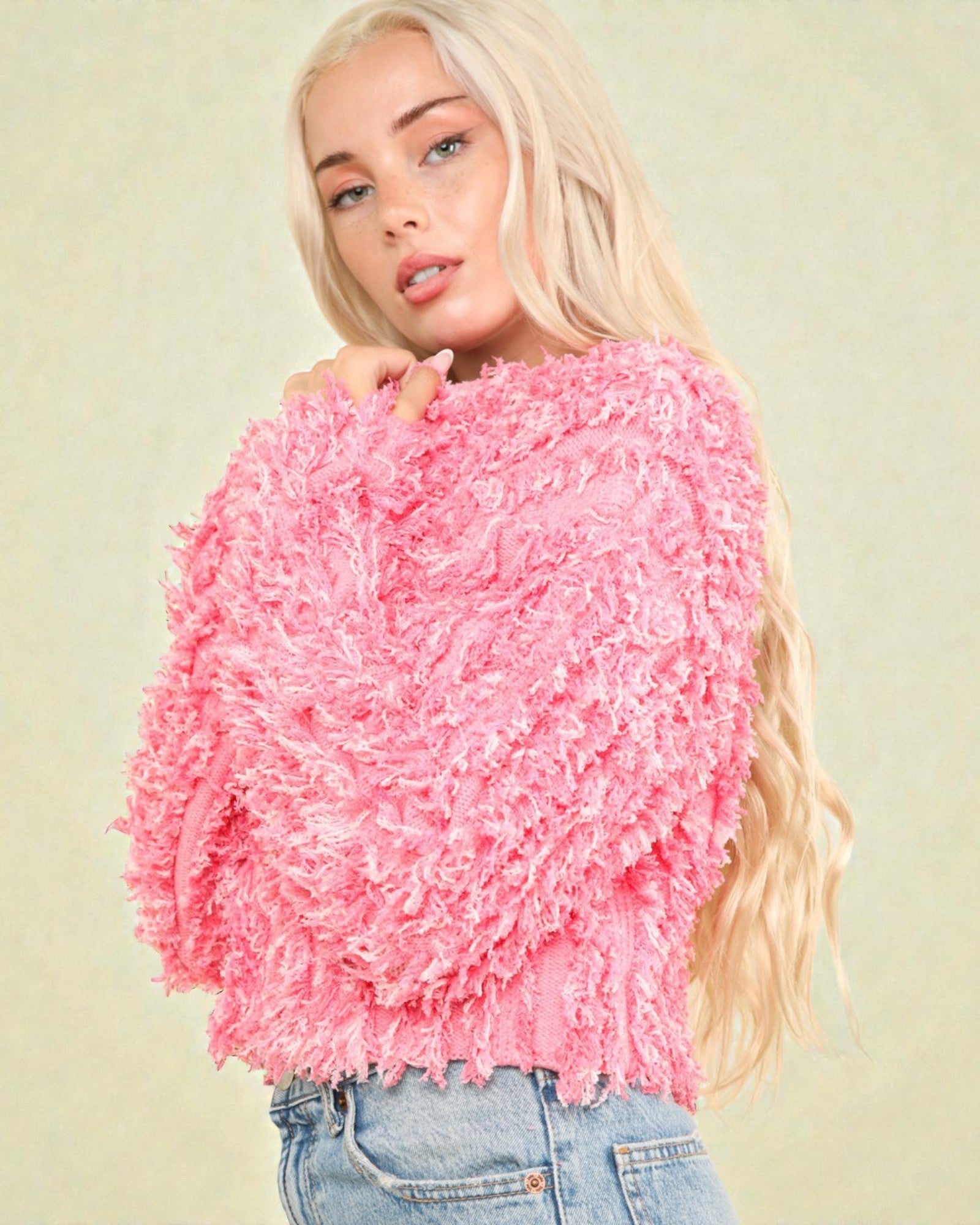 Woman wearing a pink textured sweater against a light background