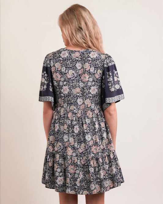 Woman wearing a floral dress with short sleeves on a beige background