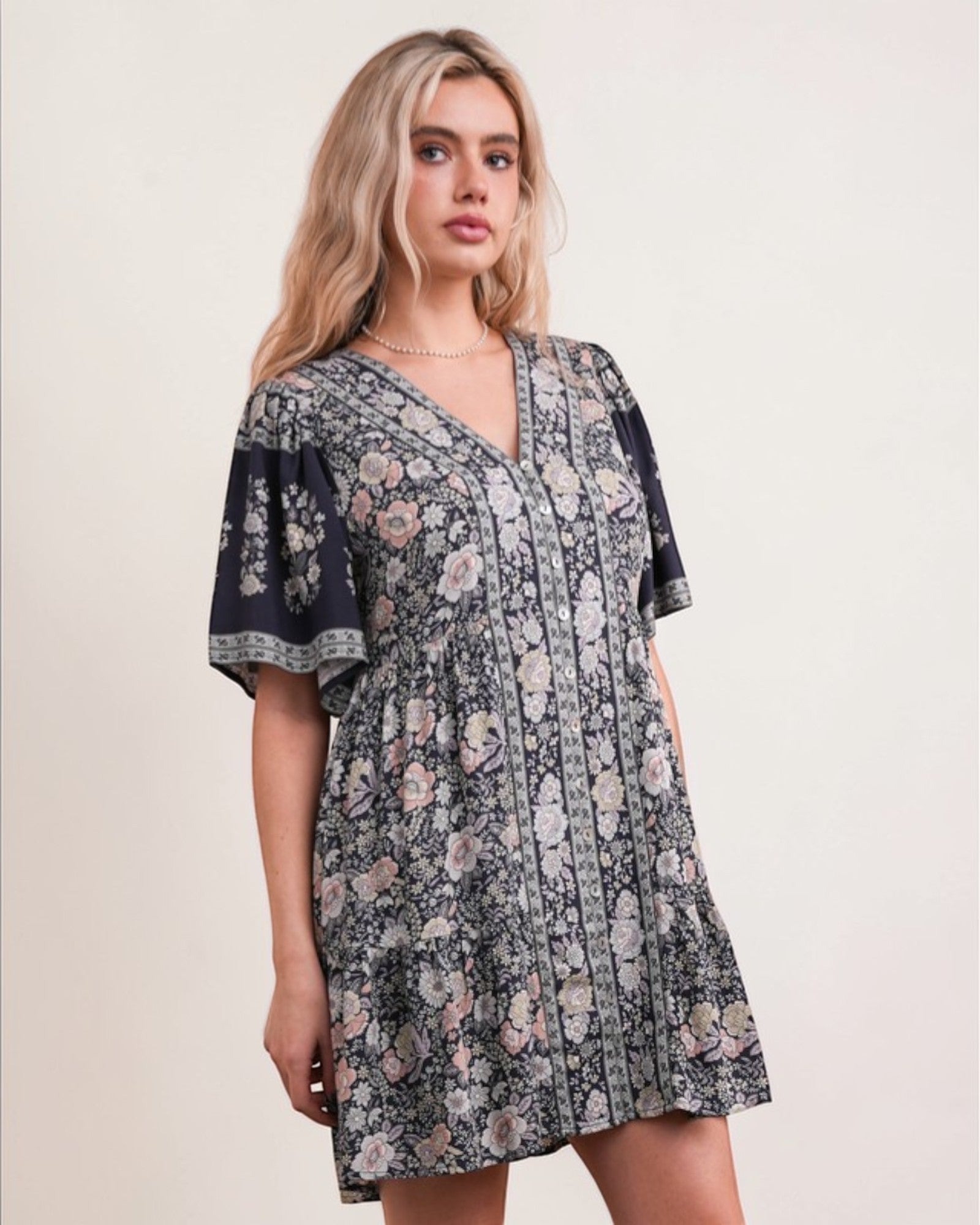 Woman wearing a floral dress against a plain background