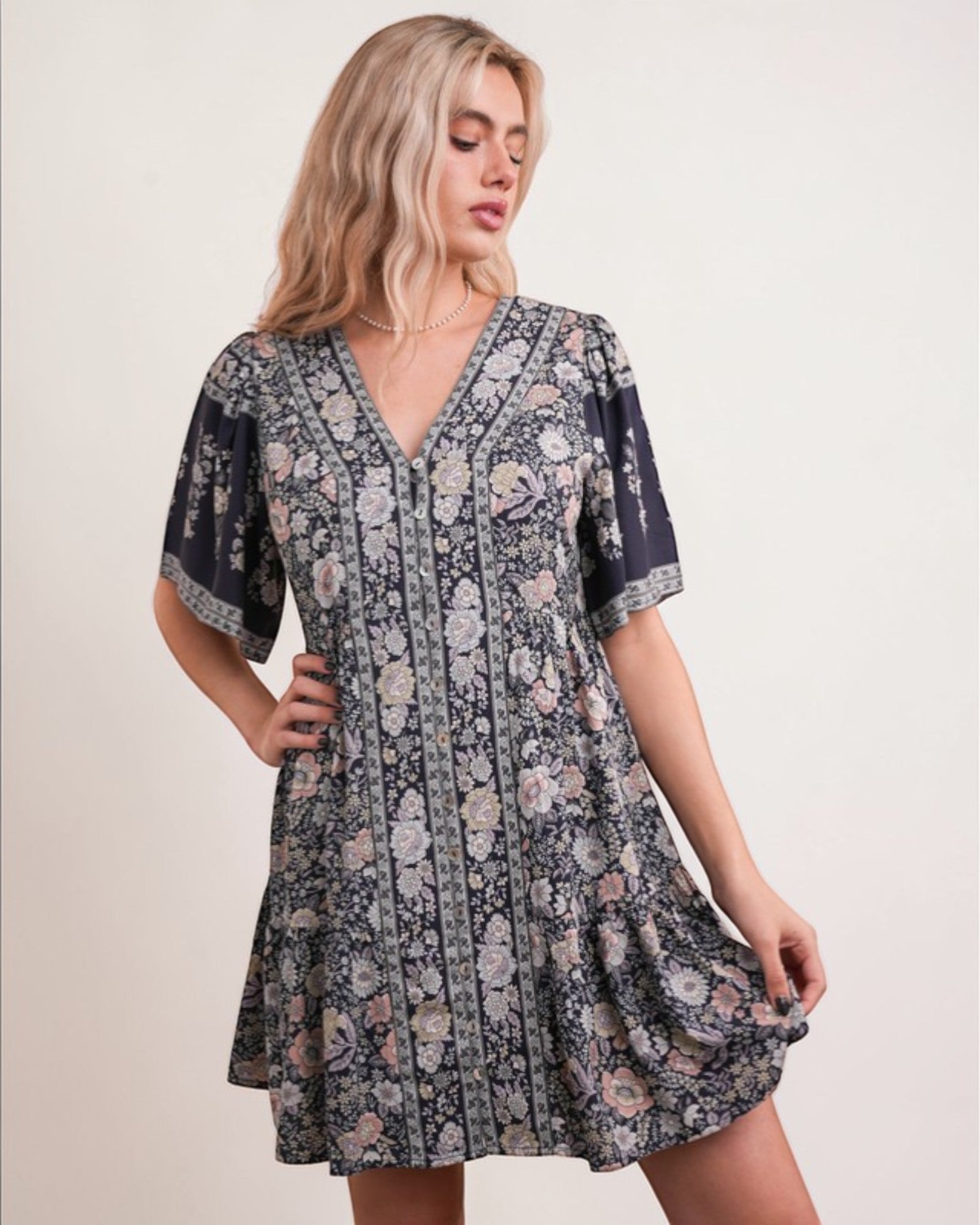 Woman wearing a floral dress against a plain background