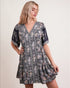 Woman wearing a floral dress against a plain background