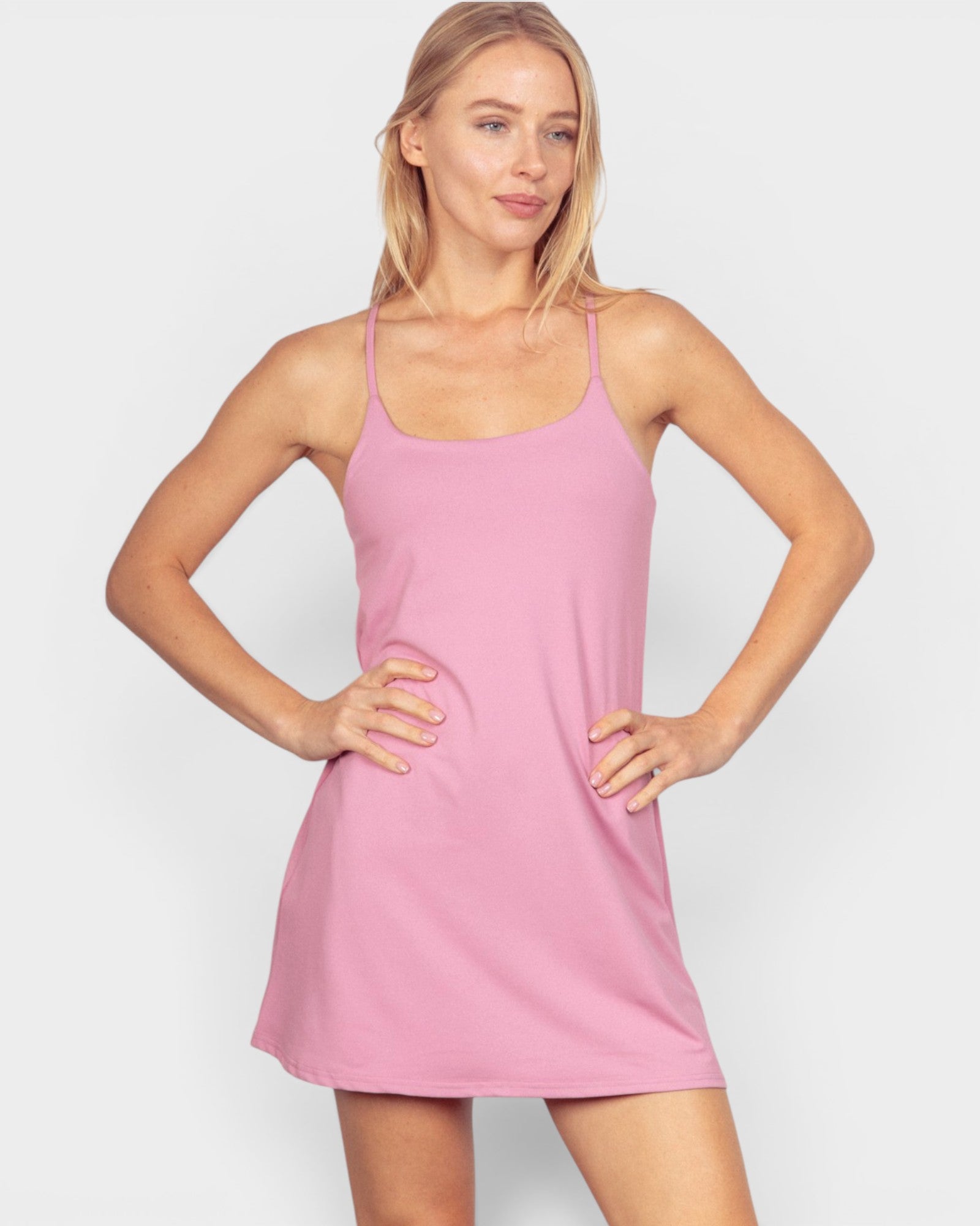 Woman wearing a pink slip dress against a white background