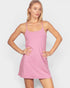 Woman wearing a pink slip dress against a white background