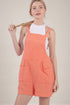 Woman wearing a coral checkered dress against a beige background
