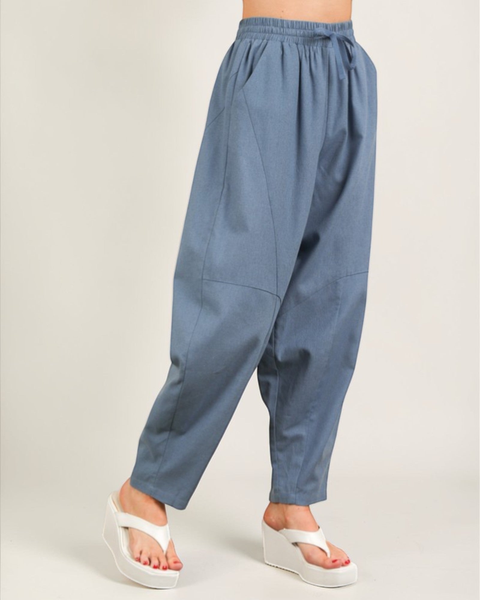 Blue baggy pants worn by a person on a plain background