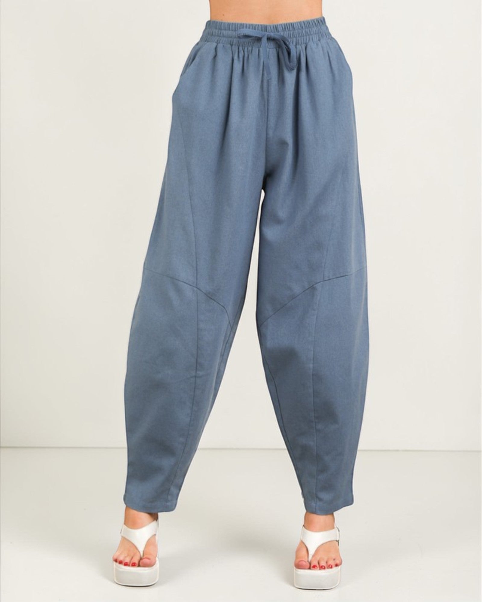 Blue wide-leg pants worn by a person on a white background