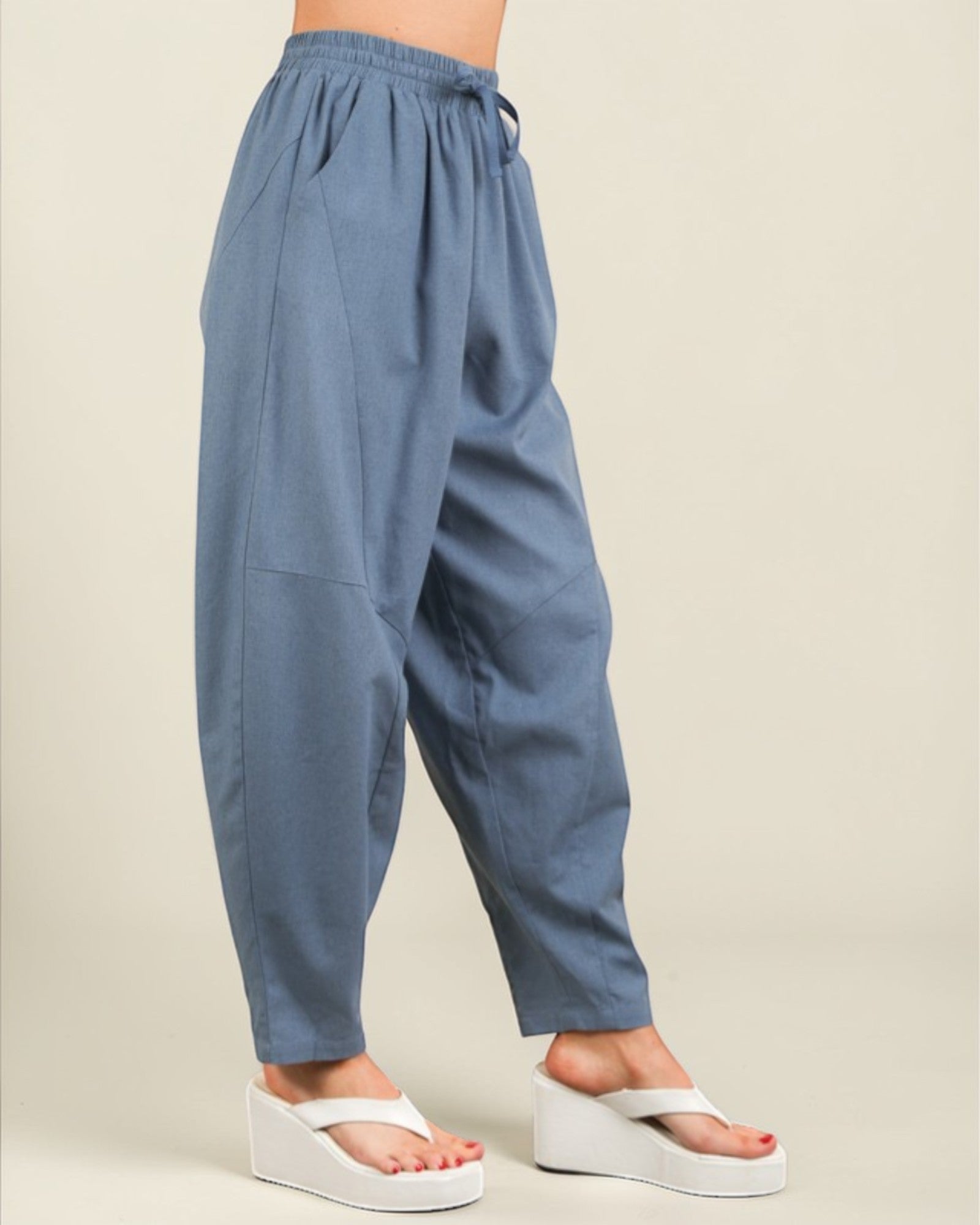 Blue pants worn by a person on a beige background