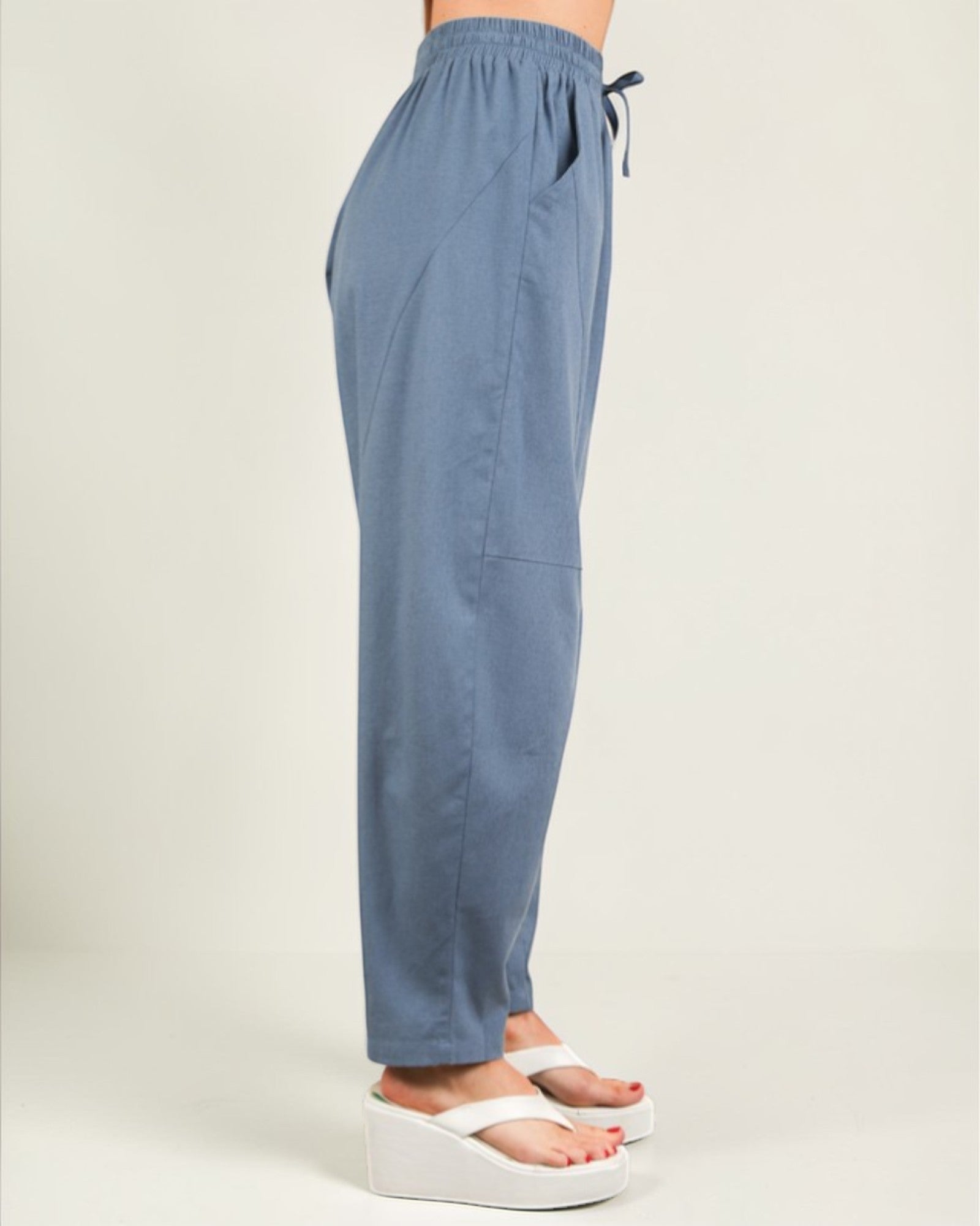 Blue pants worn by a person on a plain background