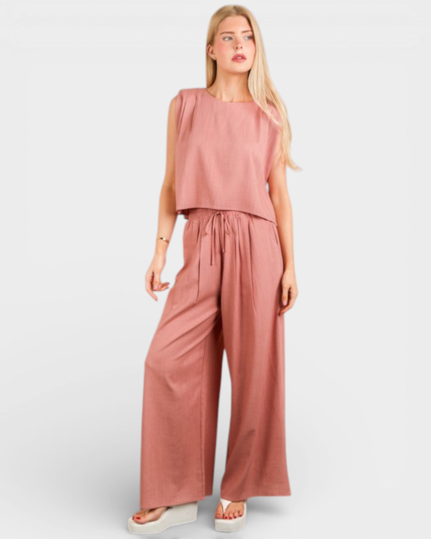 Woman wearing a pink jumpsuit on a white background