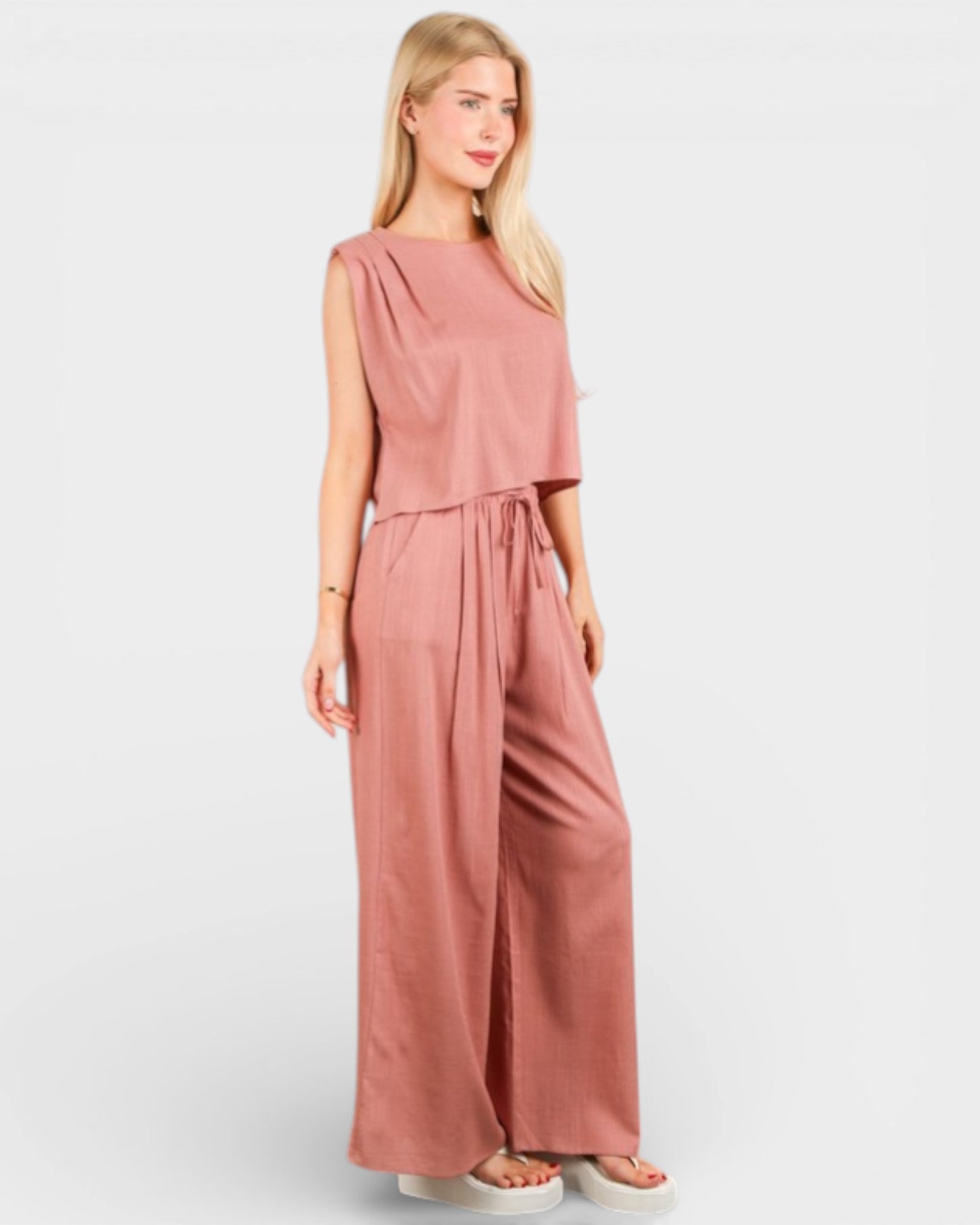 Woman wearing a pink jumpsuit on a white background