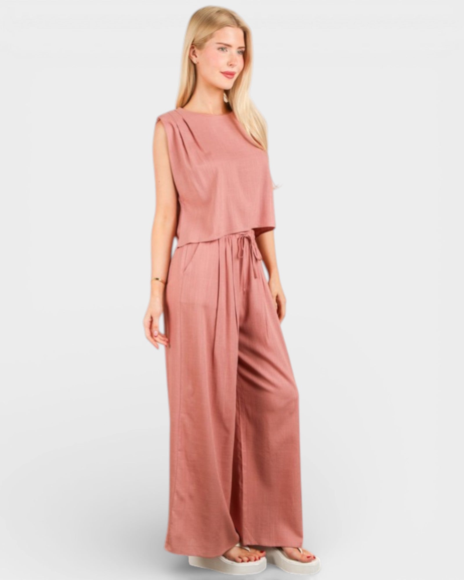 Woman wearing a pink jumpsuit on a white background