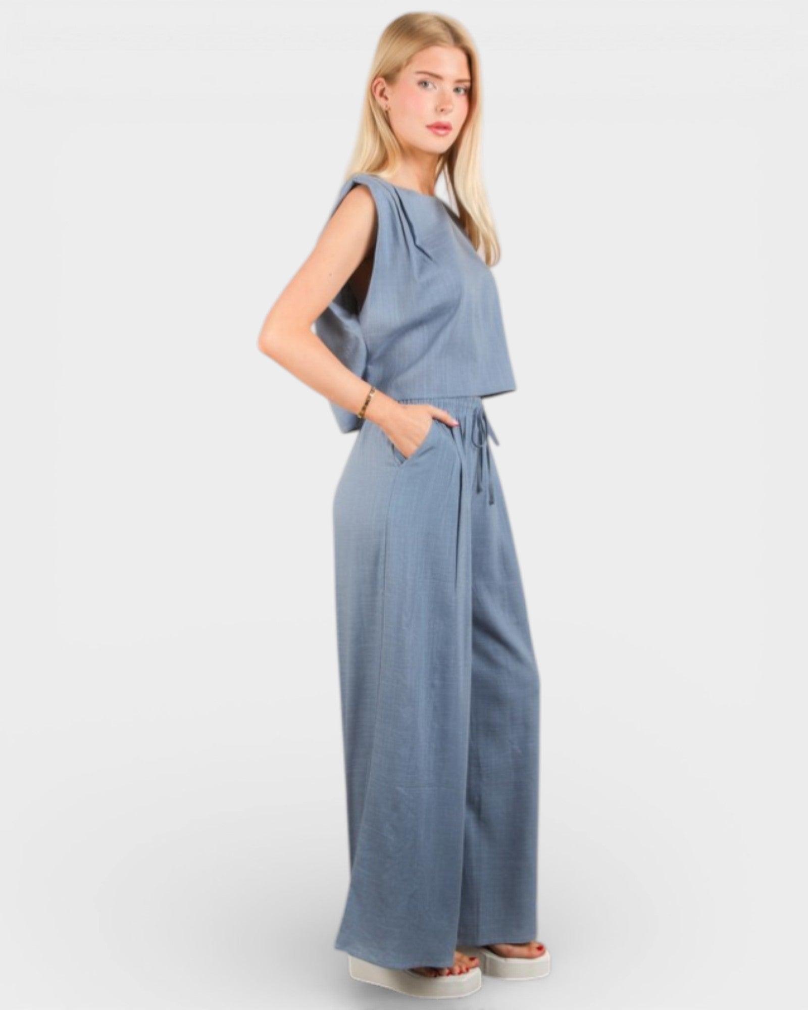 Woman wearing a blue jumpsuit on a white background