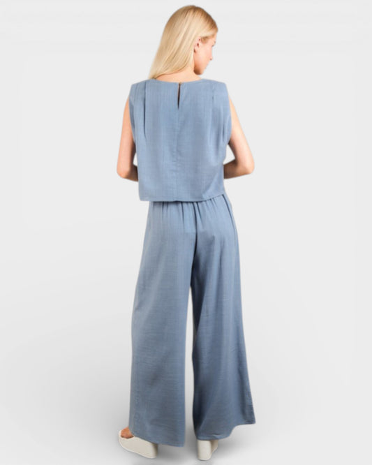 Woman wearing a light blue jumpsuit on a white background