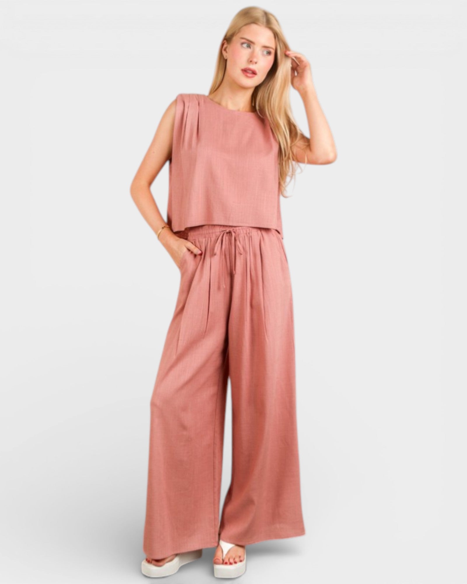 Woman wearing a pink jumpsuit on a white background