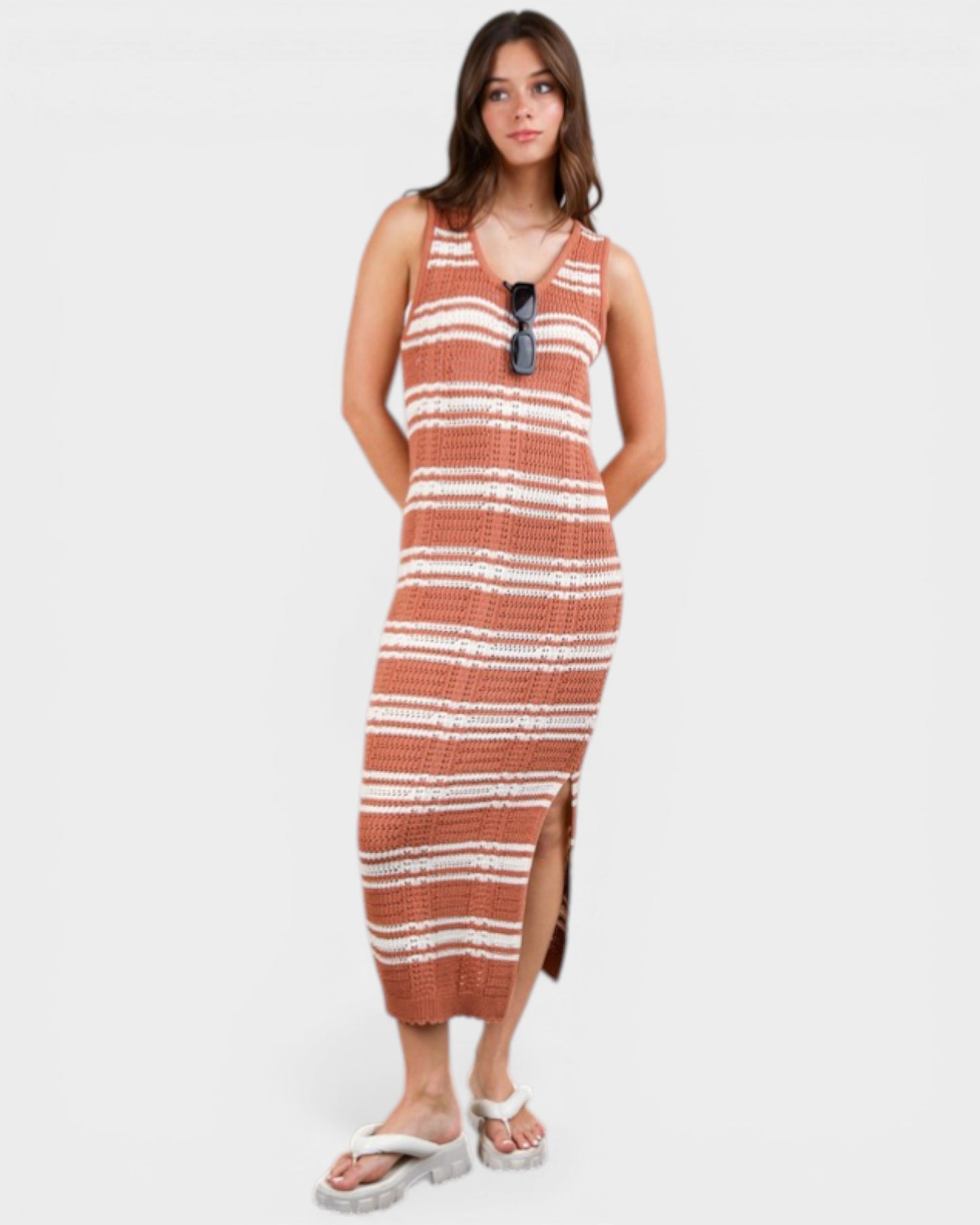 Woman wearing a striped dress with sunglasses on a white background