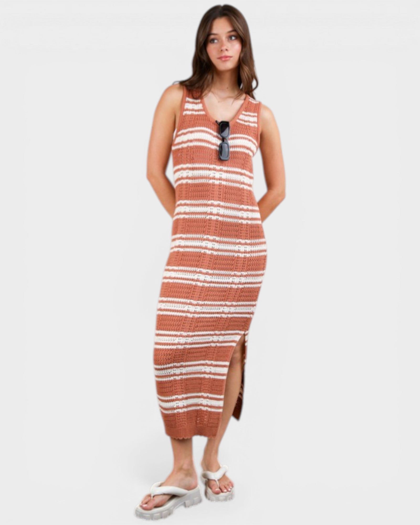 Woman wearing a striped dress with sunglasses on a white background