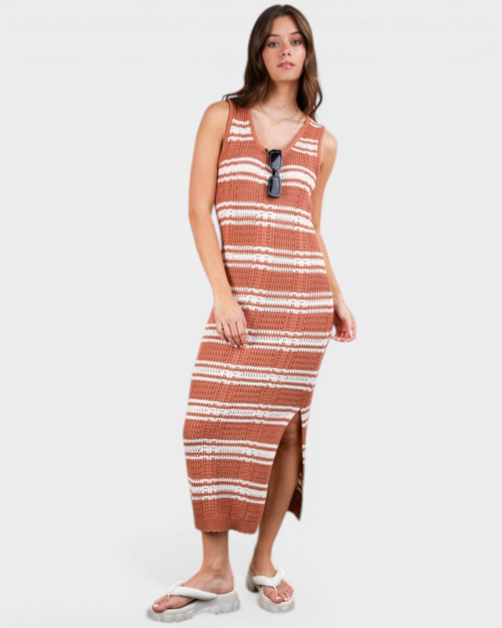 Woman wearing a striped dress with sunglasses on a white background