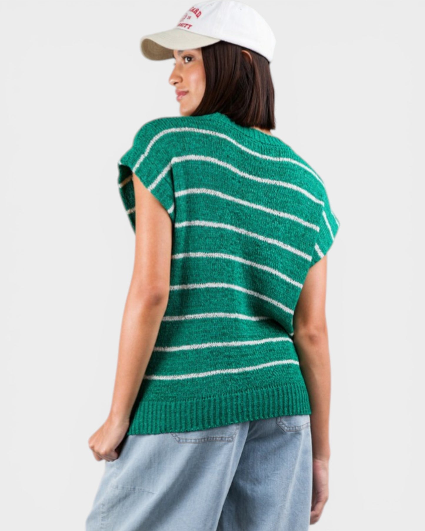 Person wearing a green and white striped sweater on a plain background