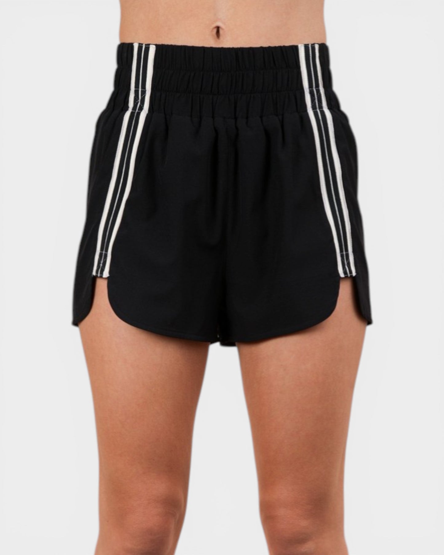 Black shorts with white stripes on a plain background