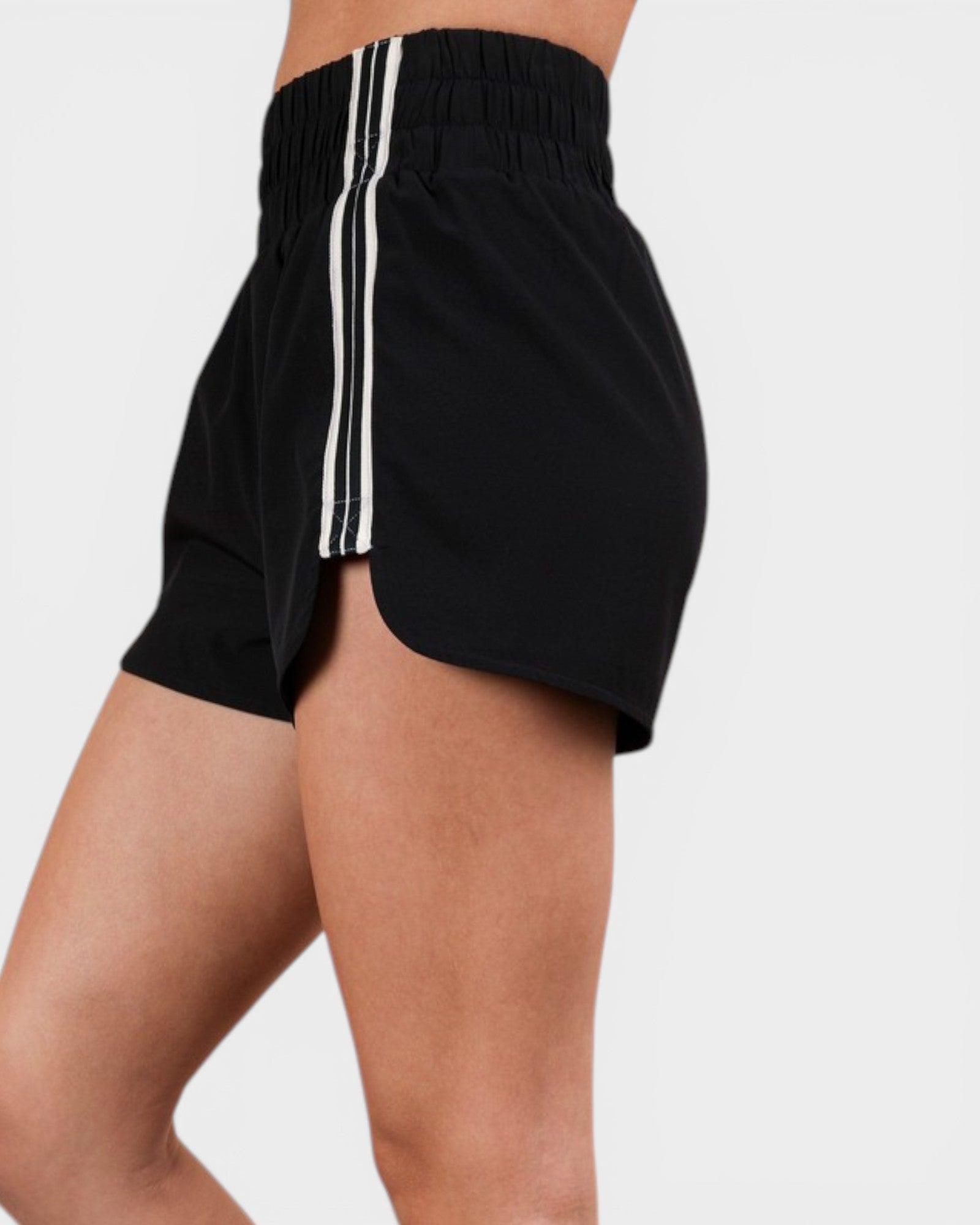 Black shorts with white stripes on a plain background