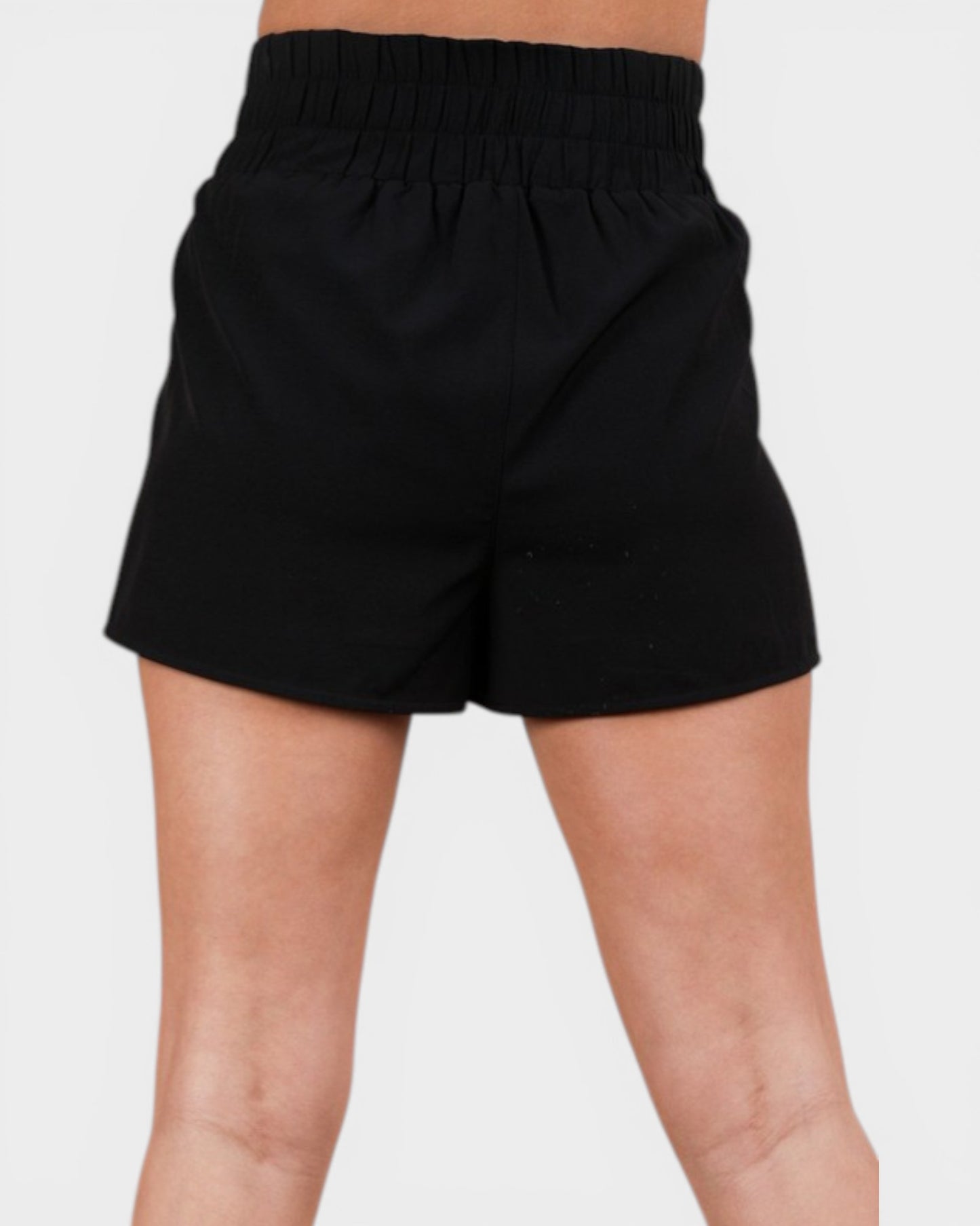 Black shorts worn by a person on a light gray background