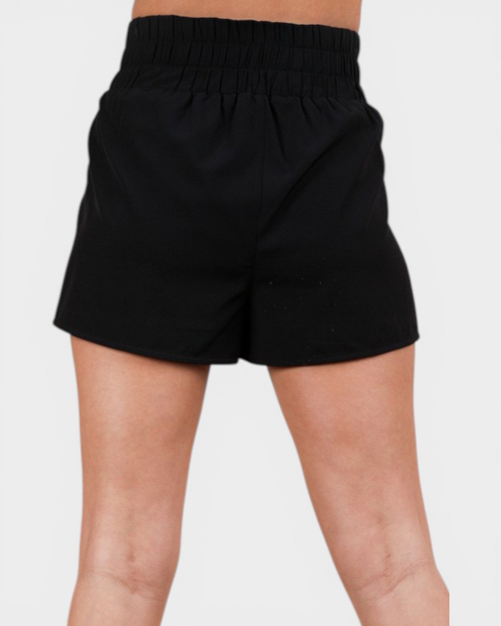 Black shorts worn by a person on a light gray background